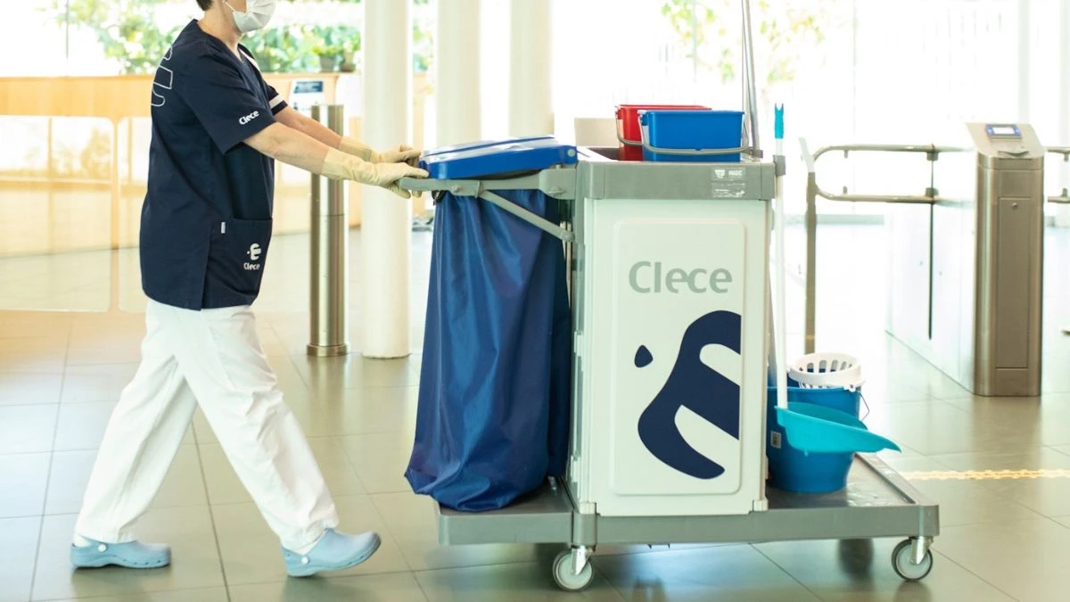 Trabajador de clece empujando un carrito de limpieza